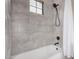 Bathroom showcasing tiled walls, black shower head, and bathtub at 5302 E Van Buren St # 2024, Phoenix, AZ 85008