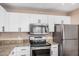 Modern kitchen featuring stainless steel appliances, granite countertops, and white cabinetry at 5302 E Van Buren St # 2024, Phoenix, AZ 85008