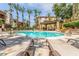 Resort-style pool surrounded by palm trees and lounge seating with shaded seating area at 5302 E Van Buren St # 2024, Phoenix, AZ 85008