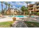 A resort-style pool with a covered seating area is surrounded by lush landscaping and palm trees at 5302 E Van Buren St # 2024, Phoenix, AZ 85008