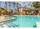 Resort-style pool featuring blue tiled entry steps and lush palm trees at 5302 E Van Buren St # 2024, Phoenix, AZ 85008