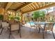 Covered outdoor seating area with tables, chairs, and a built-in grill overlooking the pool at 5302 E Van Buren St # 2024, Phoenix, AZ 85008