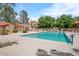Community pool surrounded by lounge chairs and mature trees for relaxation at 5704 E Aire Libre Ave # 1038, Scottsdale, AZ 85254