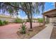 Landscaped backyard featuring a brick-paved patio, gazebo, and mature shade tree, offering a serene outdoor retreat at 6118 S 46Th Ave, Laveen, AZ 85339