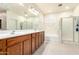 Bright bathroom boasts double sinks with wood cabinets, bathtub, and glass-enclosed shower, offering a spa-like experience at 6118 S 46Th Ave, Laveen, AZ 85339