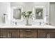 Modern bathroom with a double vanity, granite counters, illuminated mirrors, and contemporary fixtures at 6525 E Cave Creek Rd # 101, Cave Creek, AZ 85331