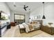 Comfortable main bedroom with a padded headboard, ceiling fan, pendant lights, and sliding glass door with natural light at 6525 E Cave Creek Rd # 101, Cave Creek, AZ 85331