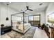 Modern main bedroom featuring a four-poster bed, ceiling fan, stylish furniture, and natural light from a sliding glass door at 6525 E Cave Creek Rd # 101, Cave Creek, AZ 85331