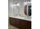 Bathroom with dual sinks, granite countertops, wood cabinets, and modern fixtures at 7222 E Gainey Ranch Rd # 232, Scottsdale, AZ 85258