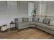 Comfortable living room with a sectional sofa, plantation shutters, and wood floors at 7222 E Gainey Ranch Rd # 232, Scottsdale, AZ 85258