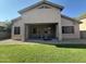 This is a picture of a home's backyard with a covered patio and a well manicured lawn at 7227 W Paradise Ln, Peoria, AZ 85382