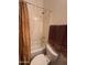 Bright bathroom with a shower-tub combo, neutral tile, and decorative shower curtain and towels at 7227 W Paradise Ln, Peoria, AZ 85382
