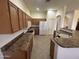 A large kitchen with a tile floor, wooden cabinets, white appliances, and a breakfast bar at 7227 W Paradise Ln, Peoria, AZ 85382