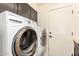 A laundry room featuring a modern washer and dryer set, with overhead cabinets for storage at 728 E Windsor Dr, Gilbert, AZ 85296