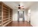 A lovely living room features built-in shelving, hardwood floors, and a modern ceiling fan at 728 E Windsor Dr, Gilbert, AZ 85296