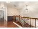 Upstairs landing with wood flooring, metal railing, and view to cabinets at 728 E Windsor Dr, Gilbert, AZ 85296