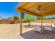 An inviting covered patio with comfortable seating and charming wind chimes offering a view of the backyard at 8569 W Fullam St, Peoria, AZ 85382