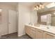 Bathroom with double sink vanity, large mirror, and neutral tile flooring at 8569 W Fullam St, Peoria, AZ 85382