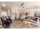 Open living room with a ceiling fan, skylight, and seating area with tile flooring and neutral paint at 8569 W Fullam St, Peoria, AZ 85382