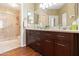 Modern bathroom with dual sink vanity, walk-in shower, and wood-look flooring at 9550 E Thunderbird Rd # 152, Scottsdale, AZ 85260
