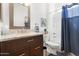 Bright bathroom featuring a shower/tub combo with a blue curtain, a marble vanity, and a decorative mirror at 9550 E Thunderbird Rd # 152, Scottsdale, AZ 85260