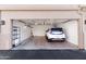 Clean and organized garage with epoxy flooring and ample storage space and a white car at 9550 E Thunderbird Rd # 152, Scottsdale, AZ 85260