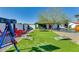 Lush backyard with artificial turf, picnic table, and seating area at 1027 S Siesta Ln, Tempe, AZ 85281