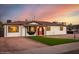 Charming single-story home featuring a manicured lawn, modern lighting, and a welcoming red front door at 1027 S Siesta Ln, Tempe, AZ 85281