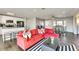Open-concept living space with hardwood floors, red sectional, and view to kitchen and dining areas at 1027 S Siesta Ln, Tempe, AZ 85281