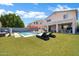 Spacious backyard with a pool, lush artificial turf, patio seating and a barbecue grill, great for outdoor living at 10430 W Los Gatos Dr, Peoria, AZ 85383