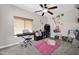 bedroom featuring a ceiling fan, a pink rug, and wall decor at 10430 W Los Gatos Dr, Peoria, AZ 85383