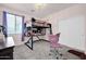 This bedroom has a lofted bed, a closet, and a comfortable work area with a stylish chair and ample lighting at 10430 W Los Gatos Dr, Peoria, AZ 85383