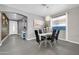 Elegant dining room with modern light fixture, sleek table setting, and stylish gray tile flooring at 10430 W Los Gatos Dr, Peoria, AZ 85383