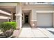 Welcoming front entrance featuring a covered porch with stone accents and a neatly landscaped garden at 10430 W Los Gatos Dr, Peoria, AZ 85383