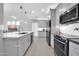 Modern kitchen boasts grey cabinets, stainless steel appliances, tile floors and expansive counter space at 10430 W Los Gatos Dr, Peoria, AZ 85383