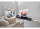 Bright living room featuring a plush sectional sofa, high ceilings, and sliding glass doors to the patio at 10430 W Los Gatos Dr, Peoria, AZ 85383