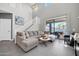 Open concept living room showcasing a staircase, a large sectional sofa, and sliding glass doors to the backyard at 10430 W Los Gatos Dr, Peoria, AZ 85383