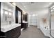 This bathroom features dual sinks, modern cabinets, and a soaking tub with a shower in a well-lit space at 10430 W Los Gatos Dr, Peoria, AZ 85383