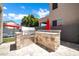 Outdoor kitchen featuring a stone countertop grill, ideal for outdoor cooking and entertaining by the poolside at 10430 W Los Gatos Dr, Peoria, AZ 85383