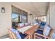 Inviting covered patio with stylish wooden table, chairs, and bright striped cushions for outdoor relaxation at 10430 W Los Gatos Dr, Peoria, AZ 85383