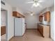 View of kitchen, featuring wood cabinets, laminate counters, white appliances, and light hardwood flooring at 10520 W Coggins Dr, Sun City, AZ 85351
