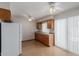 Bright kitchen featuring wood cabinets, laminate counters, white appliances, and sliding door to patio at 10520 W Coggins Dr, Sun City, AZ 85351