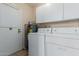 View of the laundry room with white cabinets and a stacked washer and dryer at 10520 W Coggins Dr, Sun City, AZ 85351