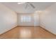 Bright living room featuring hardwood floors, ceiling fan, and a large window at 10520 W Coggins Dr, Sun City, AZ 85351