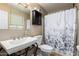 Well-lit bathroom featuring a pedestal sink with a decorative metal base and a shower with curtain at 10820 N 45Th Dr, Glendale, AZ 85304