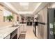 Traditional kitchen with tile floor, stainless steel refrigerator, and an undermount sink with view to the living area at 10820 N 45Th Dr, Glendale, AZ 85304
