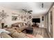 Cozy living room showcasing hardwood floors, a ceiling fan, and an opening through to the kitchen at 10820 N 45Th Dr, Glendale, AZ 85304