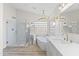 Bright bathroom showcasing a standalone tub, glass shower, and dual sinks with gold fixtures at 11089 N 130Th Pl, Scottsdale, AZ 85259