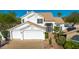 Two-story white home featuring a tile roof, manicured landscaping, and a three-car garage at 11089 N 130Th Pl, Scottsdale, AZ 85259