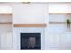 Close-up of a sleek fireplace with marble surround, wooden mantel, and built-in shelving at 11089 N 130Th Pl, Scottsdale, AZ 85259